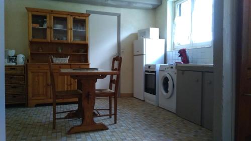 库谢韦尔尼maison de campagne的厨房配有桌子、冰箱和洗衣机。