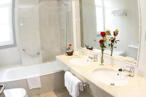 蒙达里斯-瓦尔内亚里奥孟达利兹浴场酒店的浴室配有盥洗盆、镜子和浴缸