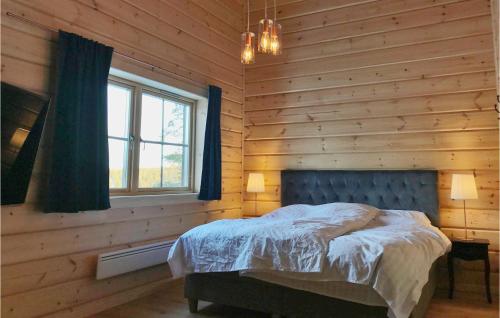 韦姆达伦Amazing Home In Vemdalen With Wifi的卧室配有木墙内的一张床