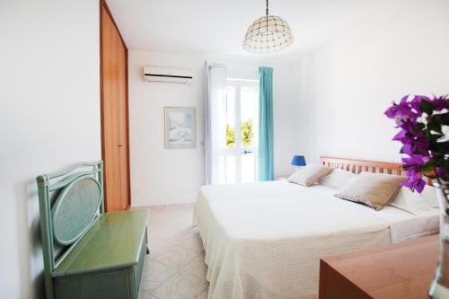 托雷桑塔萨宾娜Villa Irene的白色卧室配有两张床和椅子