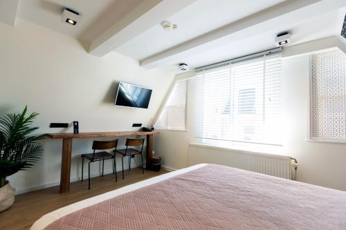 阿姆斯特丹昆汀金熊酒店的一间卧室配有一张床、一张书桌和一个窗户。