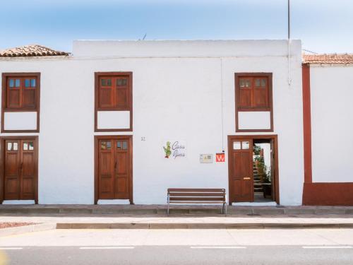 桑蒂亚戈德尔泰德Casa Fina的白色的建筑,设有木门和长凳