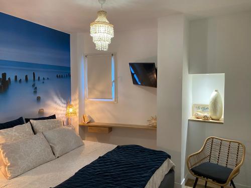 马赛Les Floralies Canebière的一间卧室配有一张床、一把椅子和一个吊灯。