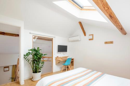 里昂Lyon Urban Cocoon Gîte urbain eco-responsable的卧室设有白色墙壁、一张床和一张书桌