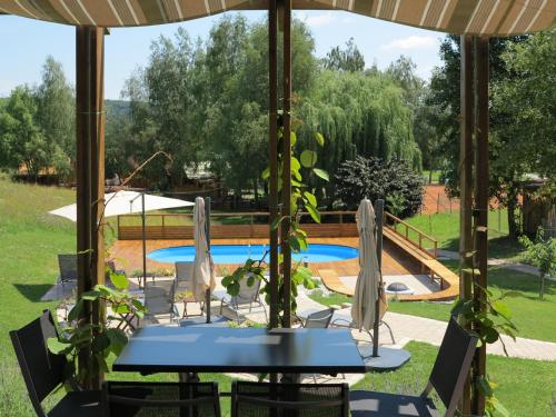 Pesnica pri MariboruNaturasort Holiday Houses的游泳池旁遮阳伞下的桌椅