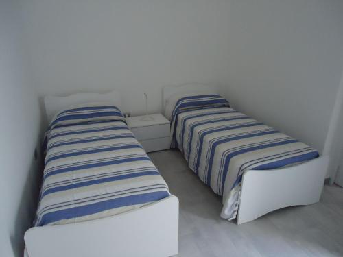 莱乌卡Appartamento Leuca的两张睡床彼此相邻,位于一个房间里