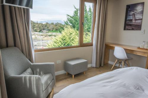 乌斯怀亚餐厅美国宾馆的卧室配有床、椅子和窗户。
