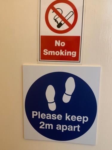 凯恩舍姆Manor Lodge Guesthouse的墙上有两个标志,上面有标志,上面写着禁止吸烟,请保持