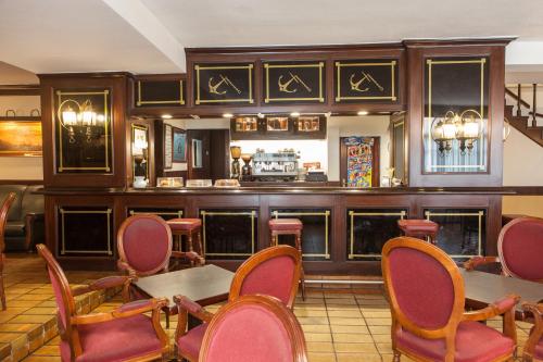 埃拉斯蒂列罗起锚旅馆的餐厅设有酒吧,配有红色的椅子和桌子