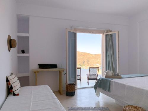 迈洛波塔斯Almyriki的白色的客房设有床和大窗户