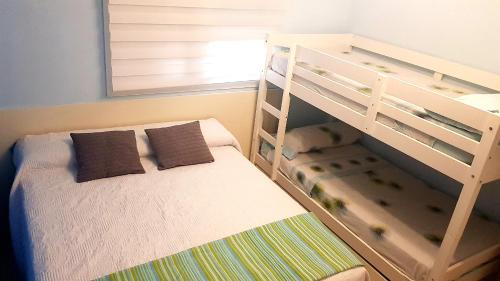 滨海罗克塔斯Apartamento Villa Romana Playa的儿童卧室配有双层床和梯子
