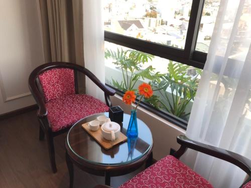 岘港Khanh Linh Hotel的客房设有桌子、椅子和窗户。