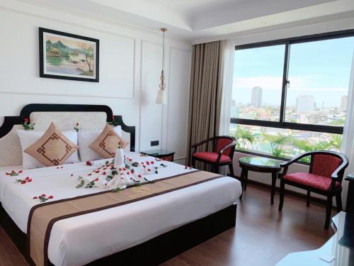 岘港Khanh Linh Hotel的一间酒店客房,床上摆放着鲜花