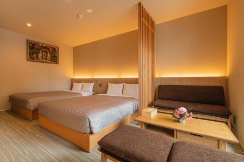 福冈GRAND BASE Fukuoka Tenjin的酒店客房,设有两张床和一张沙发