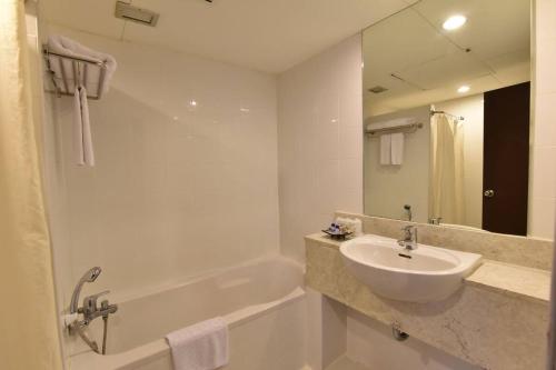 合艾金皇上豪大饭店的白色的浴室设有水槽和浴缸。