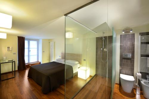 都灵特莱斯奇遇套房住宿加早餐旅馆的一间卧室设有一张床和一个玻璃淋浴间