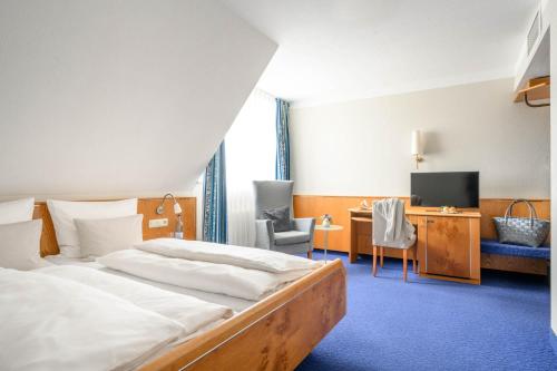 腓特烈港Hotel Maier的配有一张床和一张书桌的酒店客房