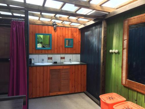 凯卡瓦自治市桑给巴尔露营旅馆的一间带两个水槽和木墙的浴室