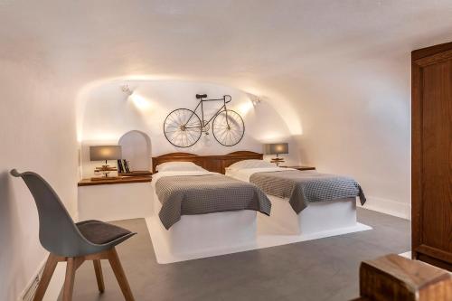 菲罗斯特法尼180° Caldera by Stylish Stays的卧室配有两张床,墙上有一辆自行车
