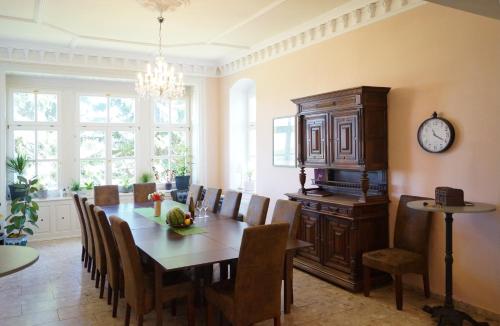库罗阿尔滕堡Villa Unger的一间带桌椅和时钟的用餐室