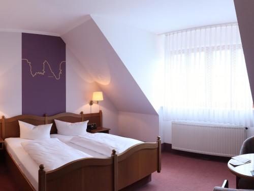 马克特布赖特米歇尔斯斯特恩酒店的一间卧室配有床、窗户和床罩。