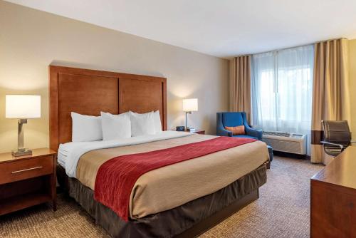克拉马斯福尔斯克拉马斯佛斯康福特茵套房酒店的酒店客房带一张大床和一把椅子