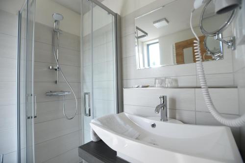 Klingenberg尼赫恩酒店的白色的浴室设有水槽和淋浴。