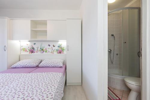 克尔克Apartment & rooms Ivica的一间带床的小卧室和一间浴室