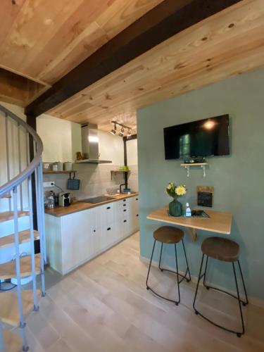 奥瑞阿卡杜佩里戈尔Petit Maison du Chêne的厨房配有一张桌子和两张凳子