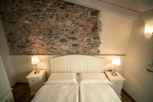利莫内-苏尔加达加尼吉安马丁酒店的一间卧室配有白色床和2个床头柜