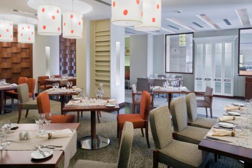 索哈尔索哈尔皇冠假日酒店的餐厅设有桌椅和吊灯。