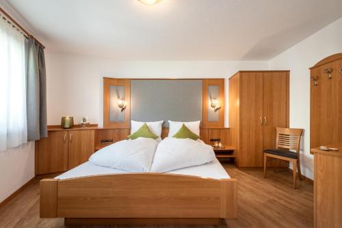 瓦尔奥纳的圣乔凡尼AlpenChalet Niederkofler的一间卧室配有带白色床单和绿色枕头的床。