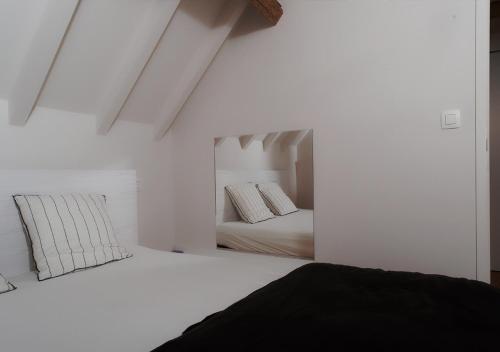 Frasnes-lez-AnvaingGîte de l'Étang的一间白色卧室,配有两张床和镜子