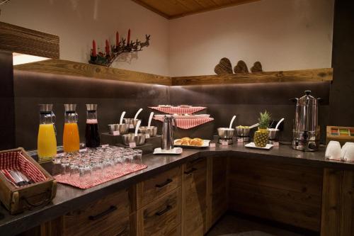措布伦Garni Hotel Wildanger的自助餐,包括饮料和玻璃杯在柜台
