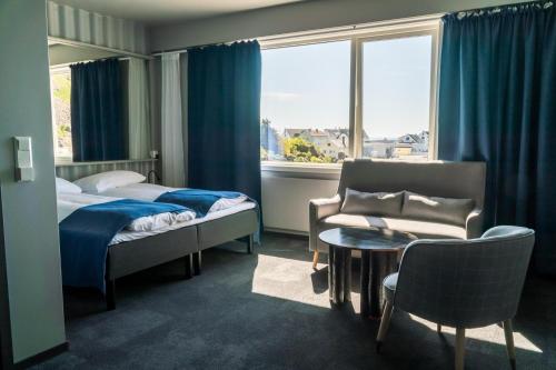 斯塔姆松Live Lofoten Hotel的酒店客房设有床、沙发和窗户。