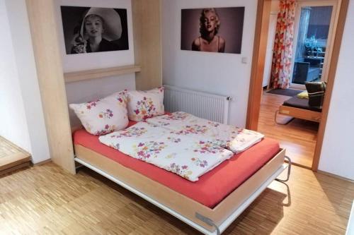 拜罗伊特Direkt im Herzen von Bayreuth Wohnung S9 mit 115qm und großem Balkon的墙上有两张照片的房间的一张床位