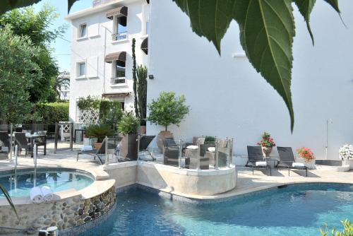 戛纳Hôtel La Villa Cannes的大楼前的游泳池