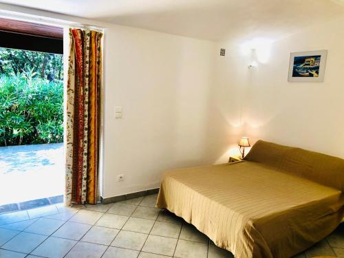维琪奥港Villa Les Lieges de Palombaggia的一间卧室设有一张床和一个大窗户