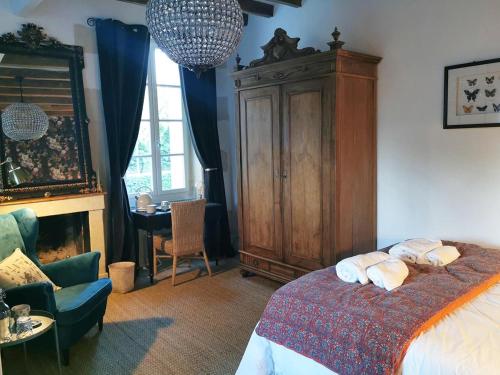 Le ThoureilQuatre Chats sous un Pin的一间卧室配有一张床和一个大型木制橱柜