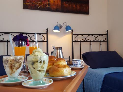 扎费拉纳-埃特内阿Poggiofelice B&B的一张桌子,上面放着两杯冰淇淋和糕点