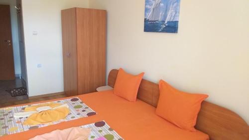 普里莫尔斯科Ivanovi Guest House的一间卧室配有带橙色枕头的床