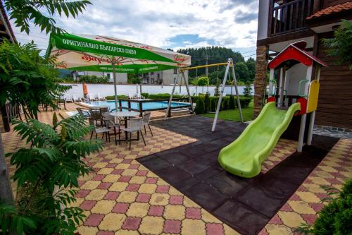 ChakalarovoVeykata Resort & Spa的一个带滑梯和桌子的游乐场以及一个游泳池
