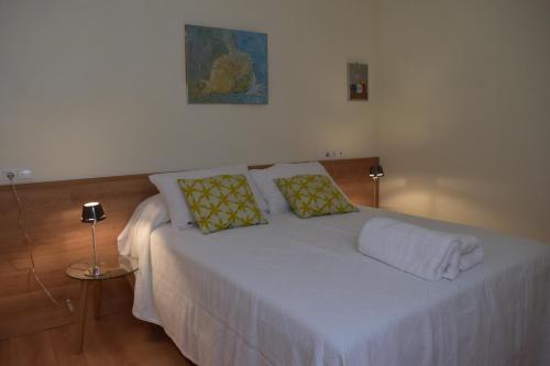 阿尔么丽亚Vivienda Bendicho- CATEDRAL的一间卧室配有带白色床单和黄色枕头的床。