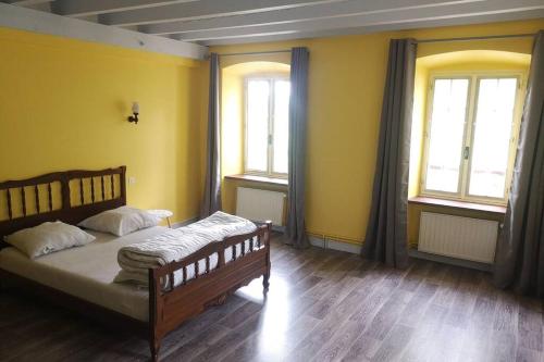 BorneLe moulin de chante oiseau的黄色墙壁和窗户的房间里一张床位