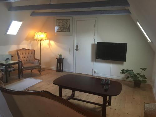 里伯登亚姆勒阿莱斯特酒店的客厅配有电视、沙发和桌子
