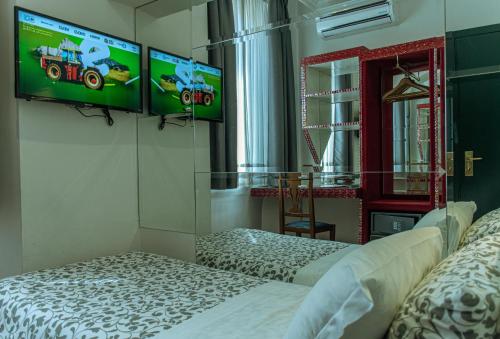 罗马卡诺瓦酒店的一间设有两张床和两个显示器的墙壁客房