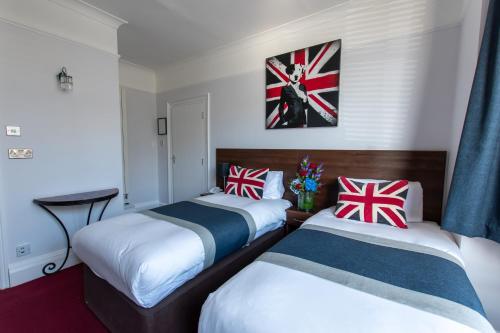 布莱顿霍夫新斯坦住宿加早餐酒店的两张床铺,位于酒店客房,墙上挂着英国国旗