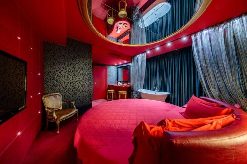 皮亚韦河畔诺文塔Base Hotel的红色卧室设有一张大床和镜子
