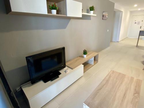萨洛APARTBEACH AGUSTINA ARAGON CLIMATIZADO y VISTAS PLAYA的客厅设有壁挂式平面电视。