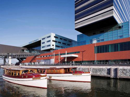 阿姆斯特丹阿姆斯特丹市中心瑞享酒店的两艘船在水中,在建筑物前